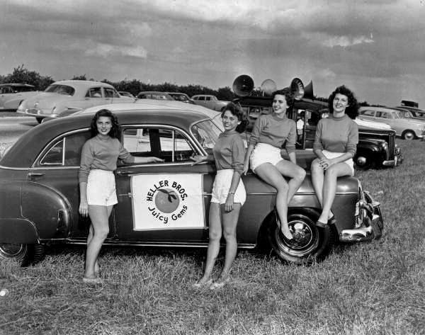 Young ladies pose with a car during an orange picking contest - Orlando, Florida.