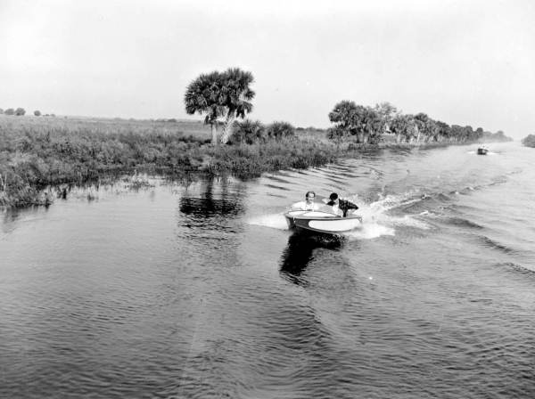 Two motorboats traveling on the water of the Kissimmee River