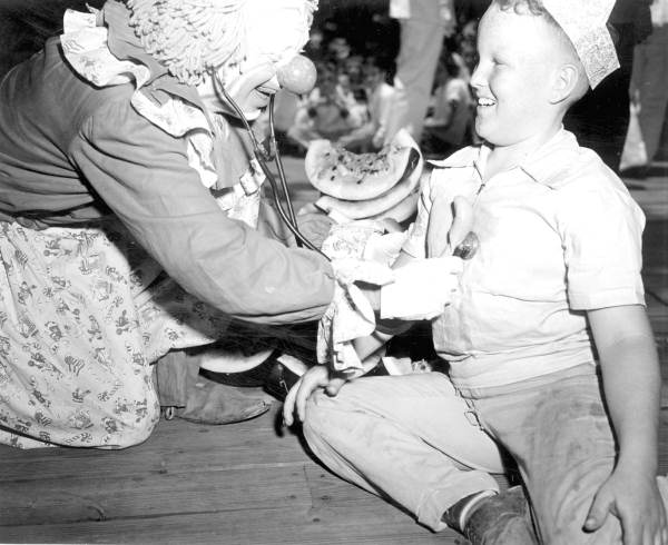 Young boy and clown at the watermelon eating contest in the watermelon festival - Leesburg, Florida