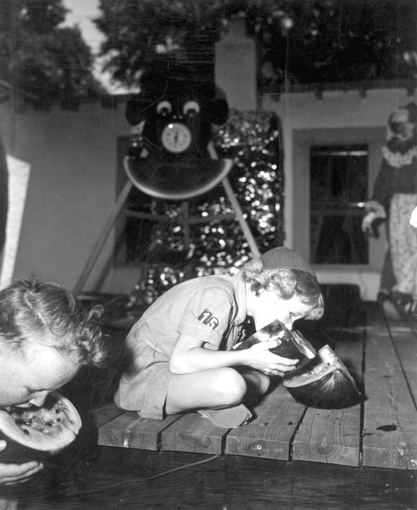 Young brownie scout and boy participating in the watermelon eating contest at the watermelon festival - Leesburg, Florida