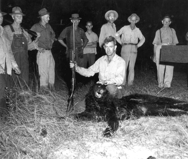 Floyd Miller poses with a killed bear - Apalachicola National Forest, Florida.