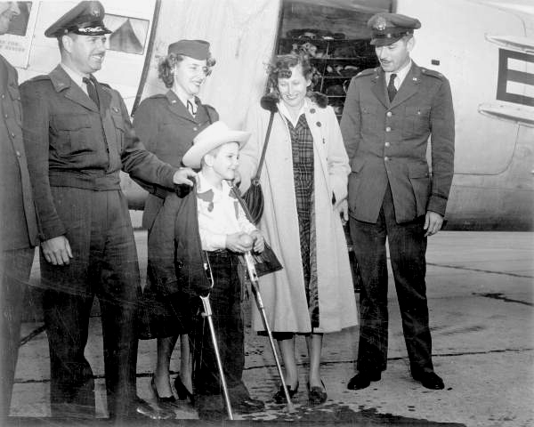 Larry Jim Gross, March of Dimes polio poster boy, with his parents and other Air Force members.