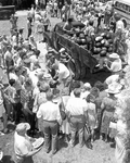 People gathered around tables to get free watermelon slices at the watermelon festival - Leesburg, Florida