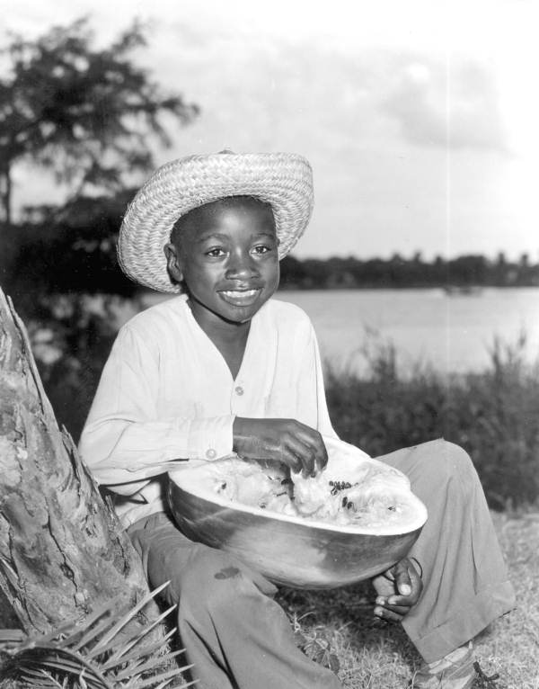 Young boy sitting in a field enjoying a slice of watermelon at the watermelon festival - Leesburg, Florida