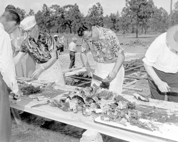 Three men cutting ribs for the Mathews Bridge barbecue - Jacksonville, Florida