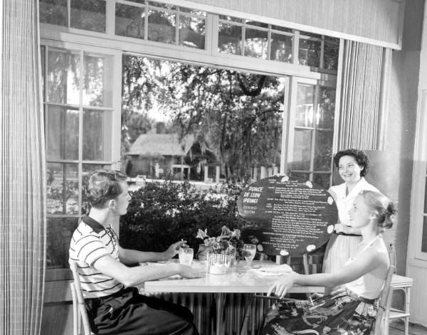 Waitress shows the menu to a couple - De Leon Springs, Florida