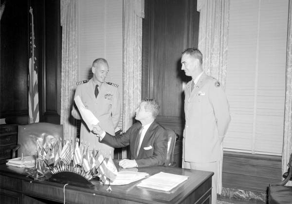 Governor LeRoy Collins signs document for U.S. Navy Captain Winslow and unidentified man.