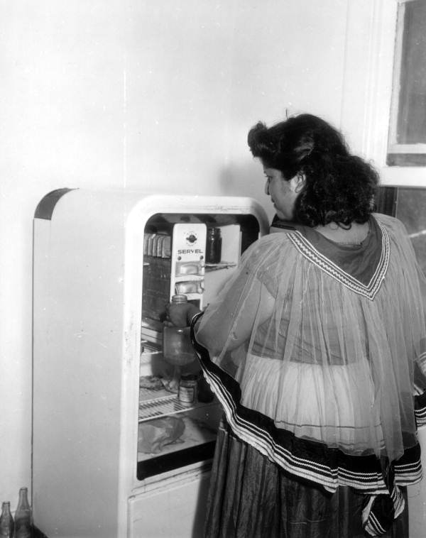 Seminole woman, Mary Bowers, fills her refrigerator in her new home