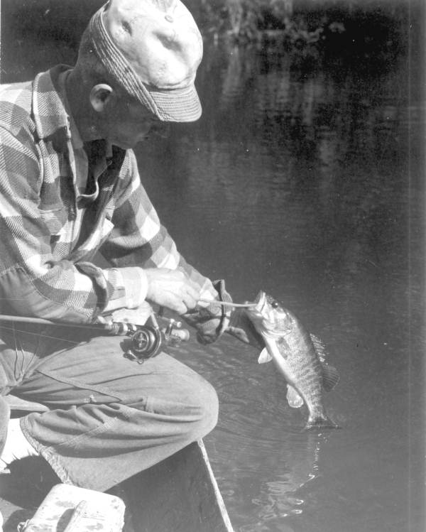 Floyd Miller unhooking his chipola bass catch - Marianna Region, Florida