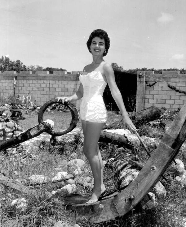 Jackie Sweeting poses on relics displayed outside the McKee's Museum of Sunken Treasure - Plantation Key, Florida