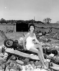 Jackie Sweeting poses on relics displayed outside the McKee's Museum of Sunken Treasure - Plantation Key, Florida