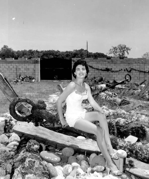 Jackie Sweeting poses on relics displayed outside the McKee's Museum of Sunken Treasure - Plantation Key, Florida