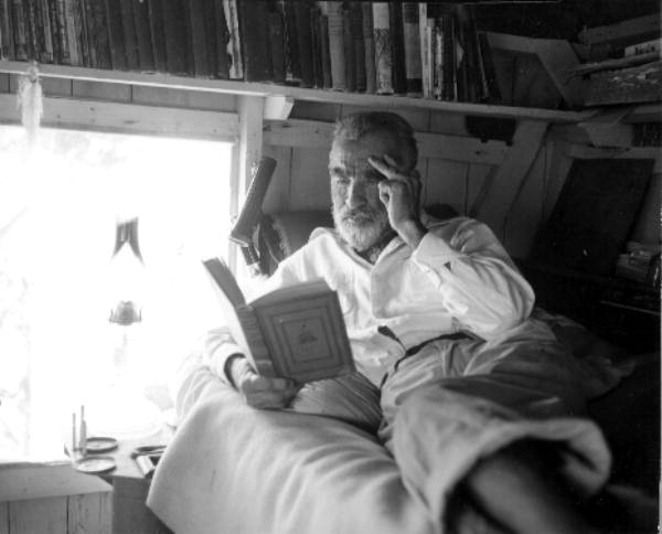 Old hermit Roy Ozmer reading a book at his house - Pelican Key, Florida.