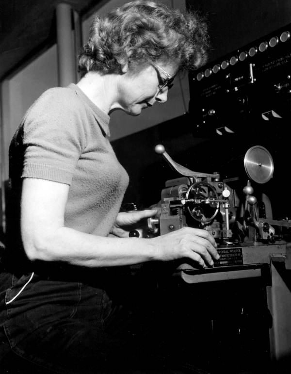 Mrs. Beulah Conley operates toroid coil winding machine..