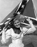 Nancy Beach posing in front of a Confederate flag - Pensacola, Florida.