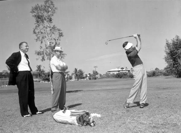 Unidentified men observe a golfer at the tournament - Naples, Florida