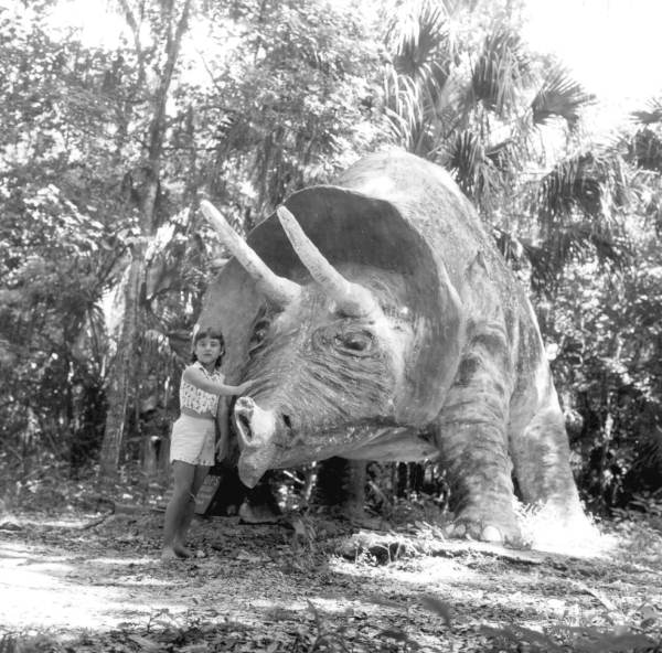 Girl with Triceratops dinosaur sculpture in Bongoland at the Dunlawton Plantation Sugar Mill Ruins - Port Orange, Florida.