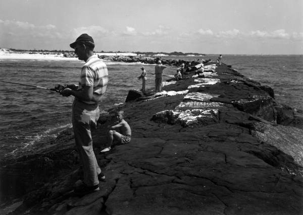 View of people fishing from the jetties at St. Andrews State Park - Panama City, Florida.