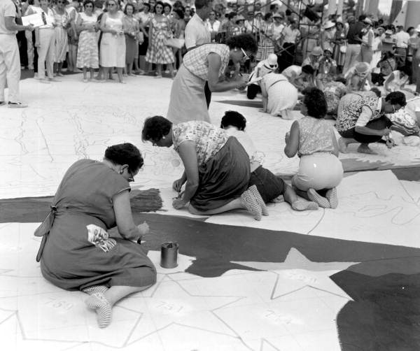 Onlookers watch others painting the canvas at the Tupperware Jubilee - Orlando, Florida
