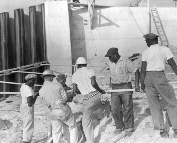 Workers connecting wing tie-back rods at spillway S-49 on canal C-24 in flood control district - Saint Lucie County, Florida