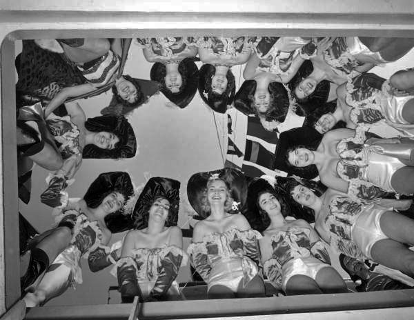 Several young women pose for a photograph, standing over the camera - Tampa, Florida.