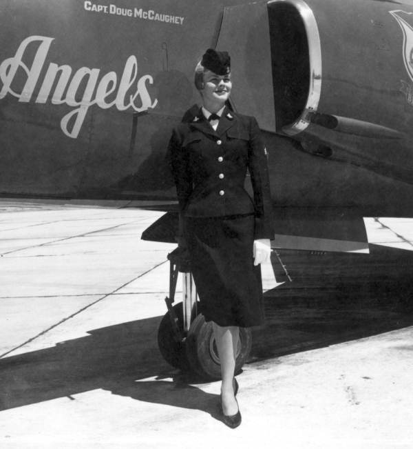 Joan Simmons poses next to a Blue Angels airplane during the anniversary of a naval air station - Pensacola, Florida.