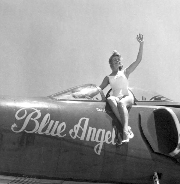 Joan Simmons poses on a Blue Angels airplane during the anniversary of a naval air station - Pensacola, Florida.