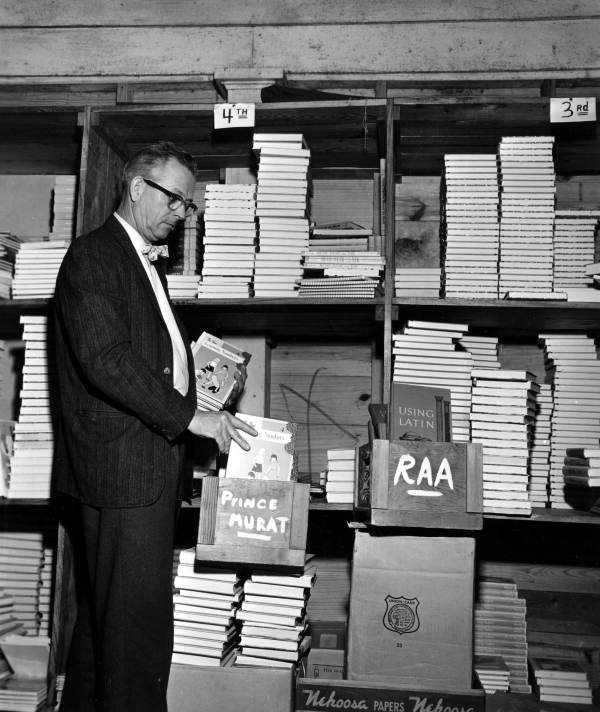 Unidentified man stacking up textbooks to be rented to county schools - Tallahassee, Florida .