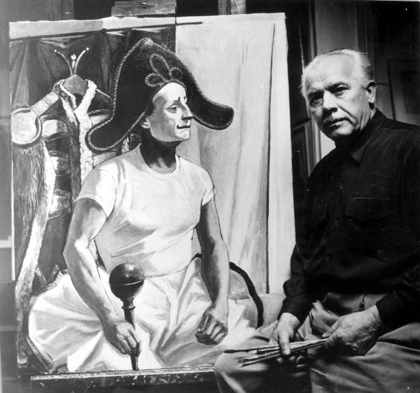 Painter Alan Gruskin sitting by a painting
