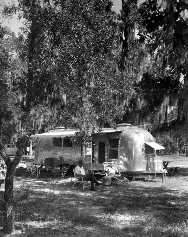 Mr. and Mrs. Herbert Smith sit by a trailer at Silver Lake Recreation Area - Apalachicola National Forest, Florida.