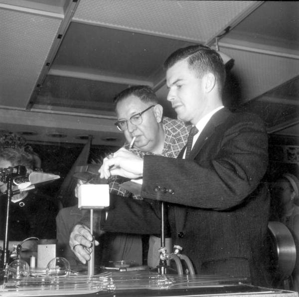 Unidentified man assists the glassblower .,
