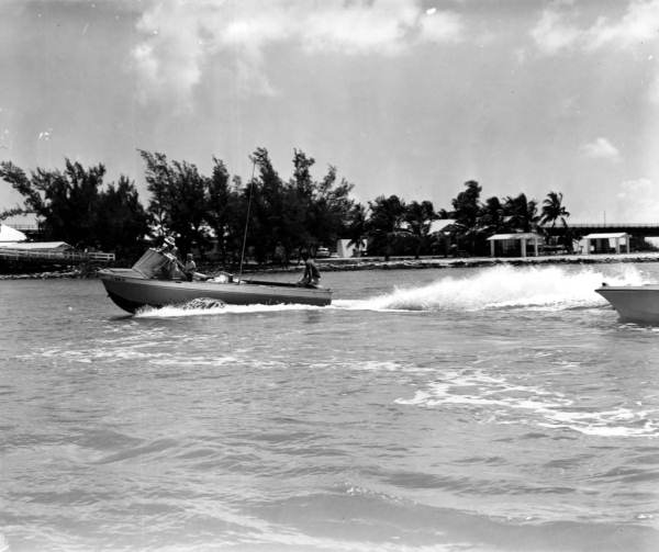 Boats roar through the water towards a picnic area on shore