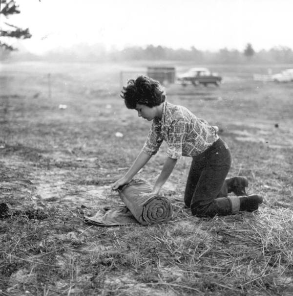 Young woman rolls her sleeping bag after a nights sleep on the Old Spanish Trail