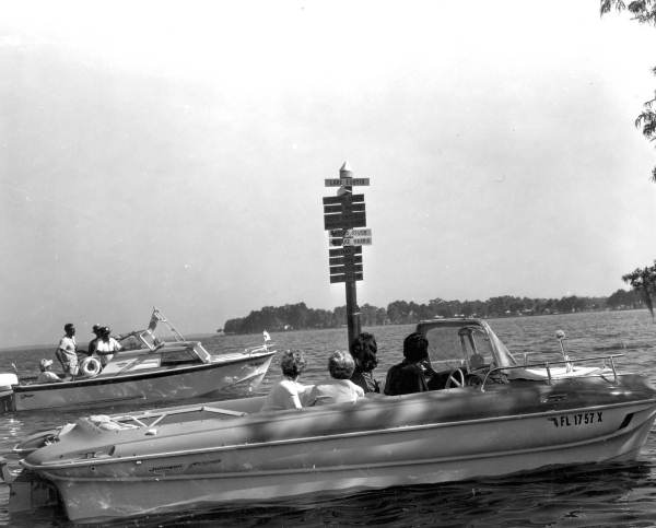 Boaters on Oklawaha River cruise at sign - Lake Eustis, Florida
