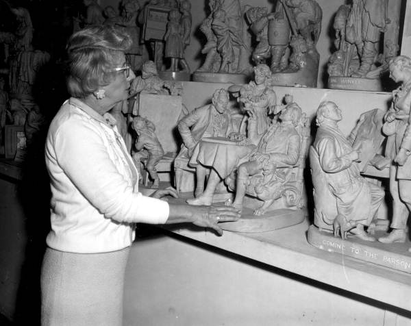 A staff member looking at porcelain figures at the Lightner Museum - Saint Augustine, Florida