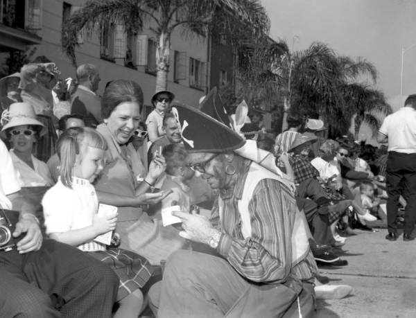 Costumed pirate entertains children during the Gasparilla parade - Tampa, Florida.