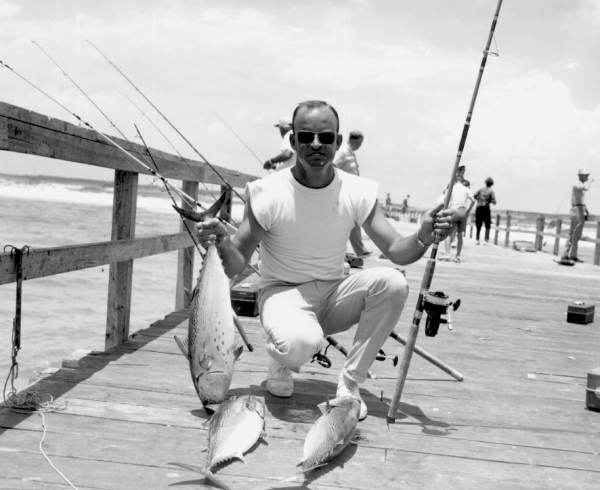 A man proudly displaying his catch of fish on the pier - Navarre Beach, Florida.