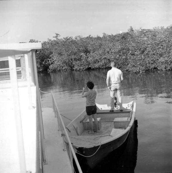 The Browers relax on a dinghy next to their houseboat