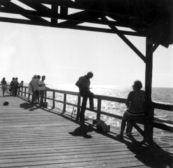 A few people fishing on the pier - Fort Myers Beach, Florida.
