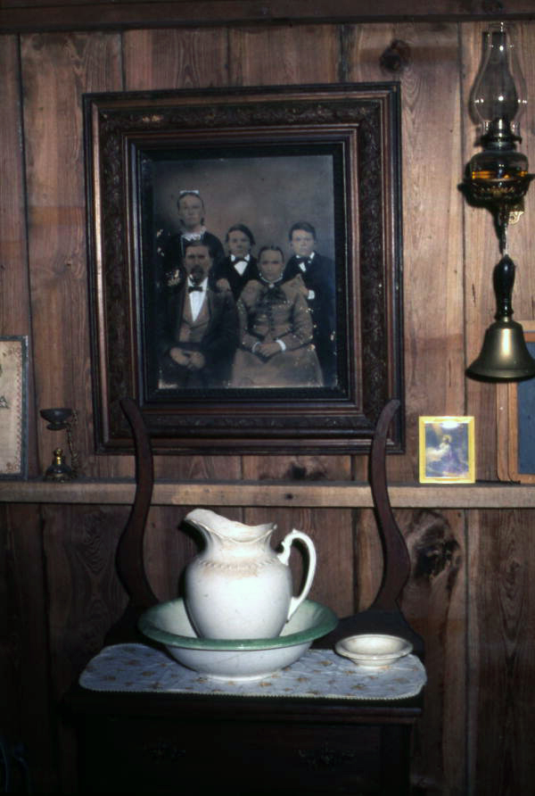 Interior view of an old house showing wash basin and family portrait at the Crowley Museum and Nature Center - Sarasota, Florida.