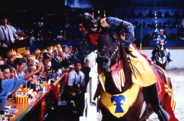 Man in medieval costume giving flower to a guest at the Medieval Times Dinner and Tournament attraction in Kissimmee, Florida.