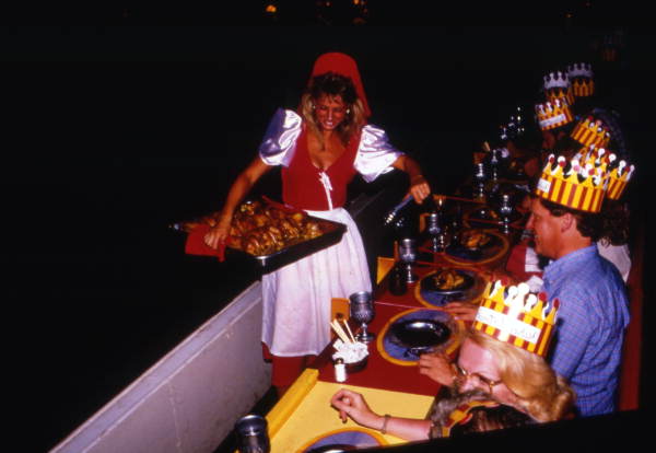 Woman in medieval costume serving food to guests at the Medieval Times Dinner and Tournament attraction in Kissimmee, Florida.