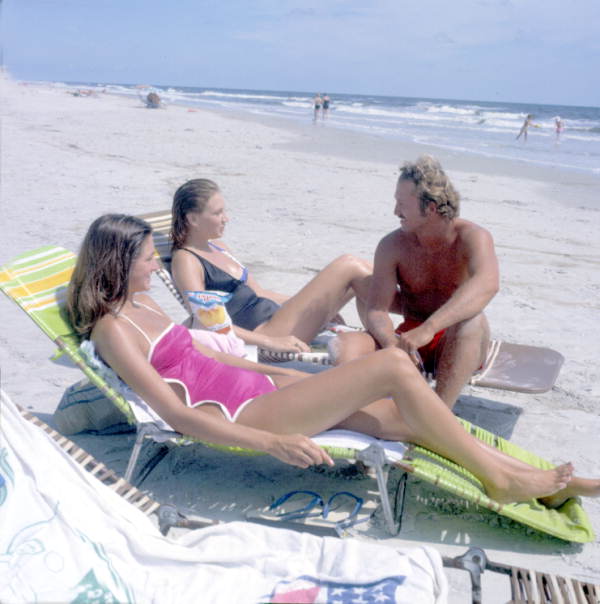 Man chatting with two women lying in the sun at the beach - Little Talbot Island, Florida