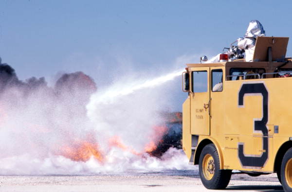 NAS Key West Fire Dept. conducting "Hot Drill" training, turret ops, on old RA-5C acft in the drill pit..