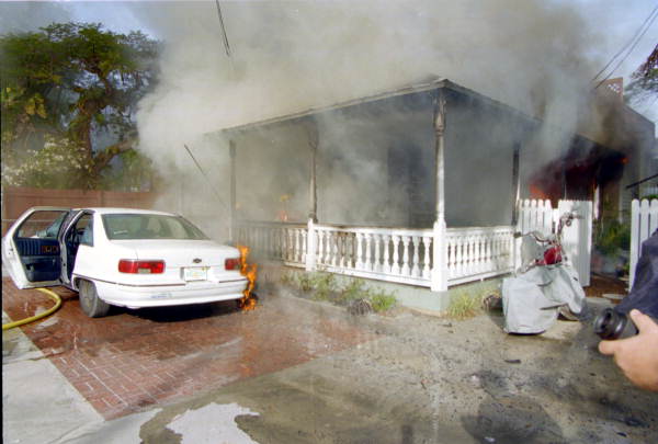 View of house fire on 1709 Flagler Ave. from the front of the structure showing fire extension to vehicle in front..