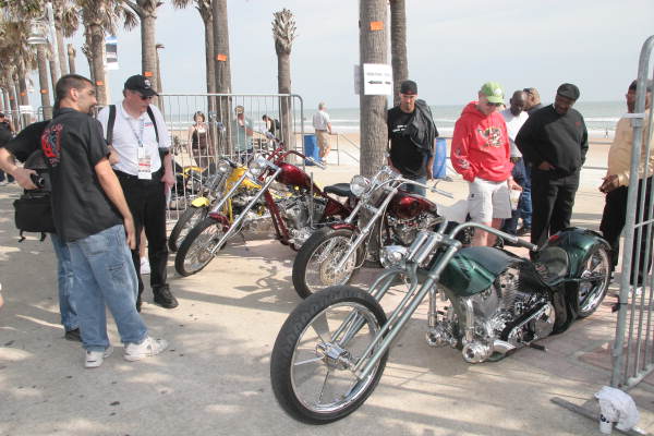 People admiring motorcycles on display for the Boardwalk Chopper and Custom Bike Show during Bike Week - Daytona Beach, Florida.