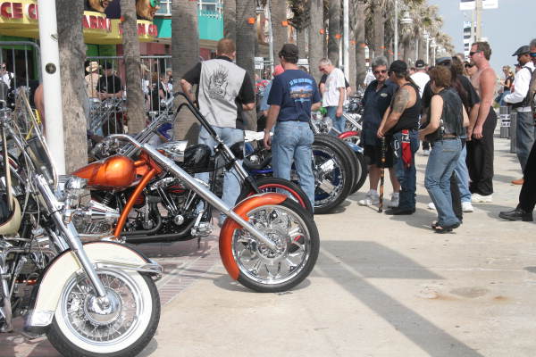 People admiring motorcycles on display during the Boardwalk Chopper and Custom Bike Show - Daytona Beach, Florida.