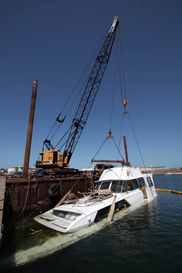 Sunk yacht being retrieved by crane from Garrison Bight Marina - Key West, Florida.