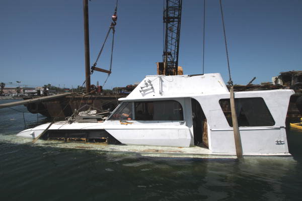 Close-up view of sunk yacht being retrieved by crane from Garrison Bight Marina - Key West, Florida.