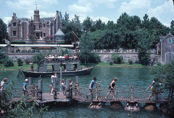 Visitors crossing barrel bridge to Tom Sawyer Island attraction at the Magic Kingdom - Orlando, Florida.